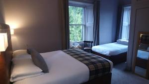 a hotel room with a bed and a desk at Benleva Hotel in Drumnadrochit
