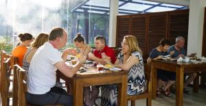 um grupo de pessoas sentadas em mesas em um restaurante em Athena Lake em Dambulla