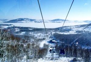 a ski lift going up a snow covered slope at Квартира студия на Банном in Yakty-Kul