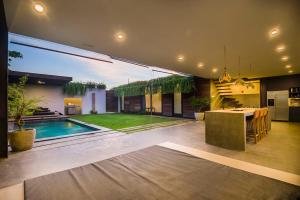a house with a pool and a kitchen and a dining room at Kontiki Villa - Joshua District in Tabanan