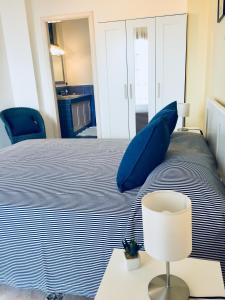 a bedroom with a bed with blue pillows and a lamp at Torre Archirafi Vacanze in Riposto