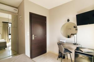 雅典Athens Iris Hotel的客房设有书桌、镜子和门