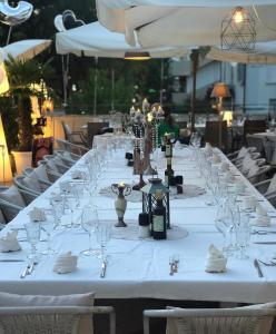 een lange witte tafel met wijnglazen erop bij 1920 Maison et Musique Hotel in Cesenatico