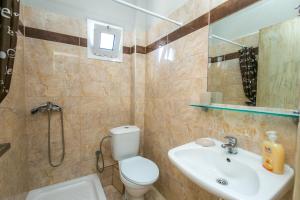 uma casa de banho com um WC, um lavatório e um espelho. em Studios Evis em Potos