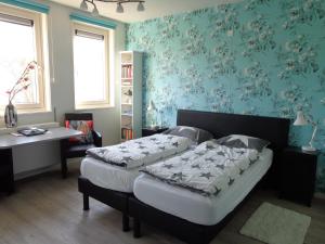 ドンブルグにあるB&B De Domburchtの青い壁紙のベッドルーム1室(ベッド2台付)