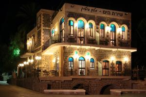 un edificio de piedra con luces azules por la noche en Shirat Hayam Boutique Hotel en Tiberias