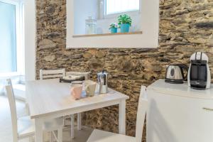 a kitchen with a white table with a coffee maker at Il Giardino di Riomaggiore Suite in Riomaggiore