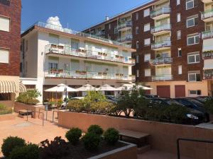 un edificio con tavoli e ombrelloni in un parcheggio di Hotel Arma Ristorante ad Arma di Taggia