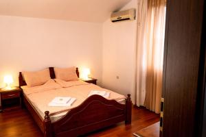 アプリルツィにあるVilla Relaxのベッドルーム1室(ベッド1台、ランプ2つ、テーブル2台付)