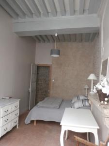 een slaapkamer met een bed en een tafel in een kamer bij Le Logis XVIIème in Moulins