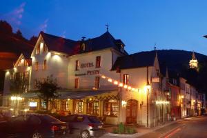 een straat met auto's geparkeerd voor een gebouw bij Hotel Petry in Vianden