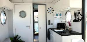 阿尔盖罗Houseboat Seabreeze的一个带水槽和镜子的大篷车内的厨房
