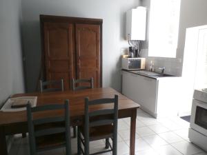 a kitchen with a wooden table and chairs and a sink at Le Logis XVIIème in Moulins