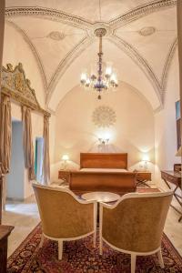 a bedroom with a bed and a table and a chandelier at Dar Ben Gacem in Tunis