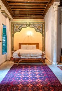 a bedroom with a bed and a rug on the floor at Dar Ben Gacem in Tunis