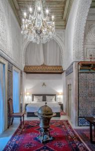 a large bedroom with a bed and a chandelier at Dar Ben Gacem in Tunis