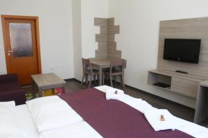Schlafzimmer mit einem Bett, einem TV und einem Tisch in der Unterkunft Hotel Palác Elektra in Ostrava