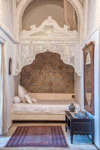 a bedroom with a bed with an ornate headboard at Dar Ben Gacem in Tunis