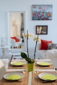 une table à manger avec des assiettes et un vase avec des fleurs dans l'établissement Les Gîtes de Claire, à Honfleur