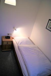 a bedroom with a bed and a night stand with a lamp at Pension Am Thieberg in Landolfshausen