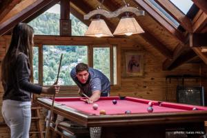 a man and a woman playing pool in a cabin at Cabañas y Spa Antuen in San Martín de los Andes