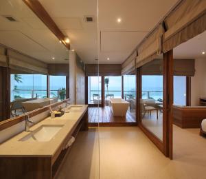 a bathroom with two sinks and a large mirror at Riff Hikkaduwa in Hikkaduwa