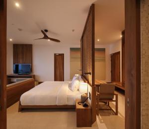 a bedroom with a bed and a desk and a chair at Riff Hikkaduwa in Hikkaduwa