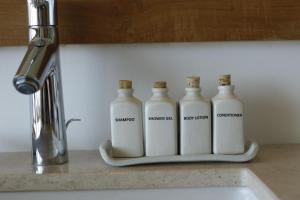 four milk bottles sitting on a counter next to a sink at Riff Hikkaduwa in Hikkaduwa