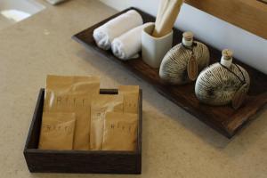 a wooden tray with paper towels and vases on a counter at Riff Hikkaduwa in Hikkaduwa