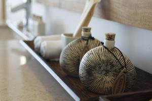 two vases are sitting on a wooden shelf at Riff Hikkaduwa in Hikkaduwa