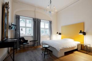 a bedroom with a bed and a desk and a piano at Hotel Fregehaus in Leipzig