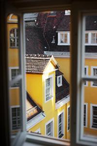 una ventana con vistas a un edificio amarillo en Hotel Fregehaus en Leipzig