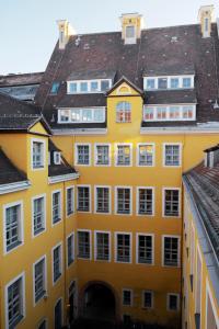 un edificio amarillo con ventanas blancas y techos en Hotel Fregehaus en Leipzig