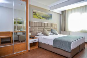 A bed or beds in a room at Hakcan Hotel