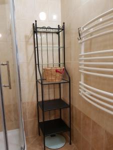 a black shelf in a bathroom with a shower at Sakuranbo - Hostel in Budapest +36 photos