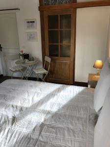 a bedroom with a large white bed and a table at Rose Garden Mezzanine in Giverny