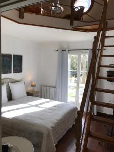 a bedroom with a large bed and a ladder at Rose Garden Mezzanine in Giverny