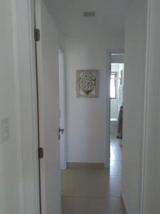 a hallway with white walls and a white door at Praia do Forte - Apartamento Iberostate in Mata de Sao Joao