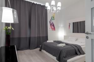 a bedroom with a bed and a chandelier at New Modern Top Floor Residence in Helsinki