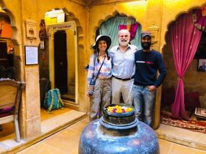 Un hombre y una mujer de pie junto a un jarrón. en Desert Haveli Guest House, en Jaisalmer