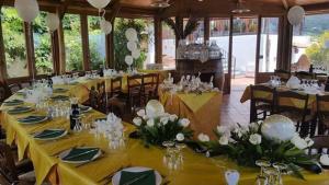 a banquet hall with tables with yellow tablecloths and white flowers at agriturismo u zu peppino in Lipari