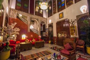 フェズにあるRiad Dar Mansouraのリビングルーム(赤いソファ、階段付)