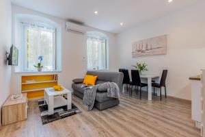 - un salon avec un canapé et une table dans l'établissement Julia apartments, à Rijeka