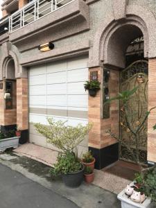 a pair of garage doors on a building with potted plants at Feng Su in Donggang