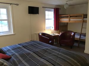 a bedroom with a bed and a desk and a bunk bed at The Old Inn in Gairloch