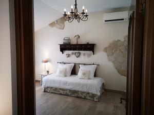 a bedroom with a bed with white sheets and a chandelier at B&B Villa Blanche in Cannes