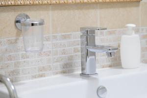 a bathroom sink with a glass of water next to a faucet at Campi Flegrei House in Naples