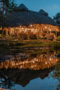 a hut with a reflection in the water at night at El Valle Lodge in El Valle