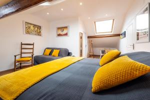 Un dormitorio con una gran cama amarilla con almohadas amarillas en B&B Charlestown, en Charleville-Mézières