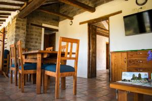 a dining room with a table and chairs and a tv at Remanso El Tobal in Tibasosa +16 photos